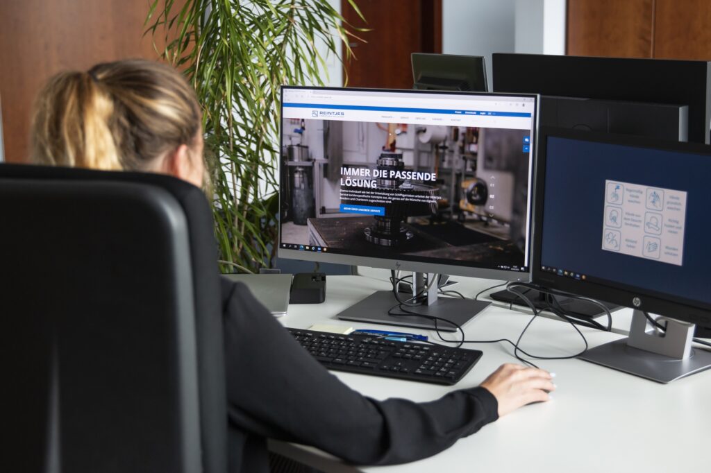 Eine REINTJES Mitarbeiterin an einem Schreibtisch vor einem Computer in einem Büro am Standort Hameln.