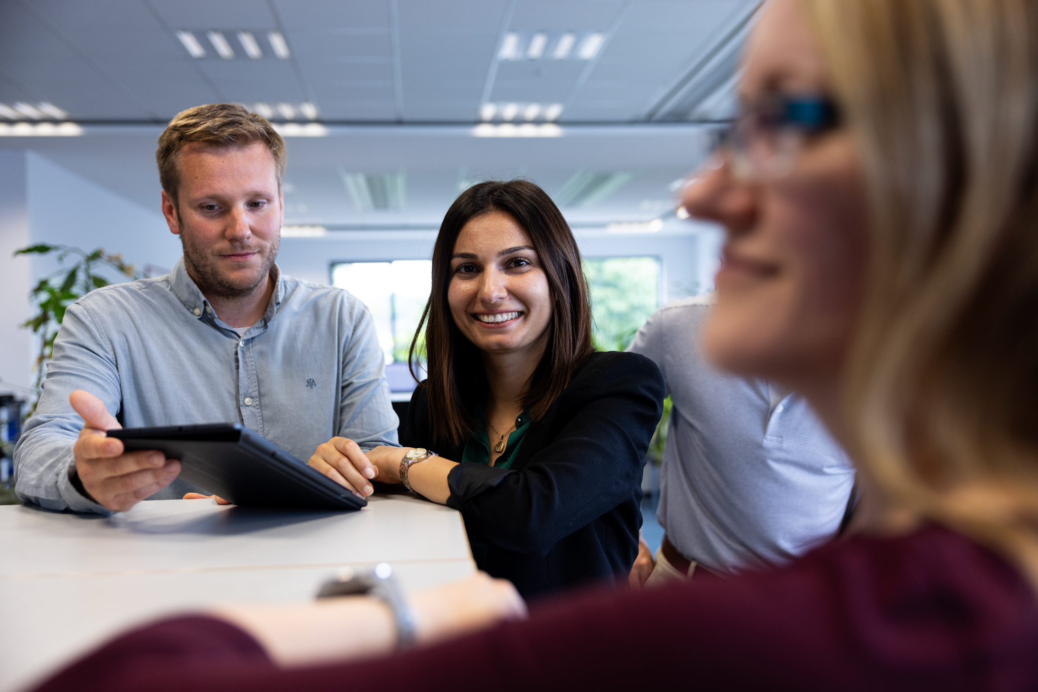 REINTJES Mitarbeiter und Mitarbeiterinnen mit einem Tablet in einem Büro am Firmensitz in Hameln.