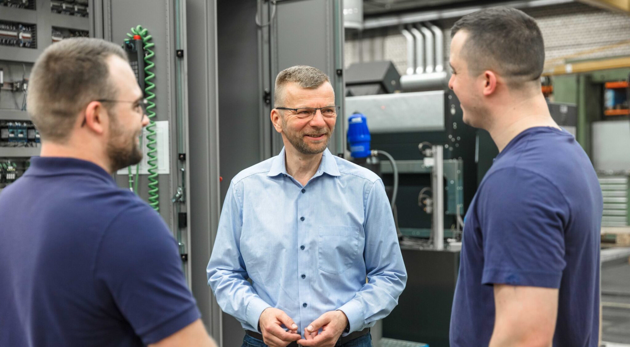 Drei REINTJES Mitarbeiter im Gespräch in einer der Produktionshallen am Standort in Hameln.